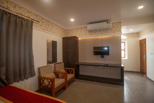 a living room with a tv on the wall at Hotel Town Palace in Shimoga