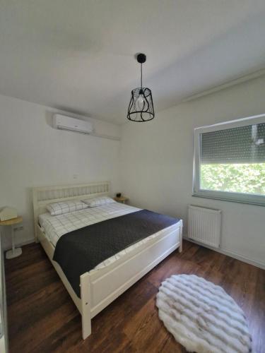 a bedroom with a white bed and a window at Little Aria in Ripač