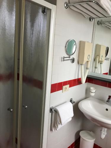 a small bathroom with a sink and a shower at Hotel Colombo in Lido di Jesolo