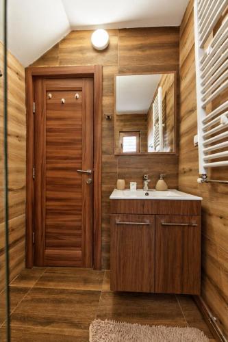 a bathroom with a sink and a wooden door at Brvnara Mont in Zlatibor