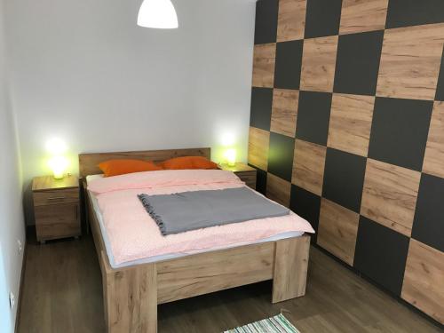クリニツァ・ズドルイにあるApartament Jaworzyna Krynickaの小さなベッドルーム(ベッド1台付)とチェッカーボードの壁が備わります。