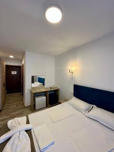 a bedroom with a bed and a desk with a mirror at Hotel Nalba-Dalia Jupiter in Jupiter