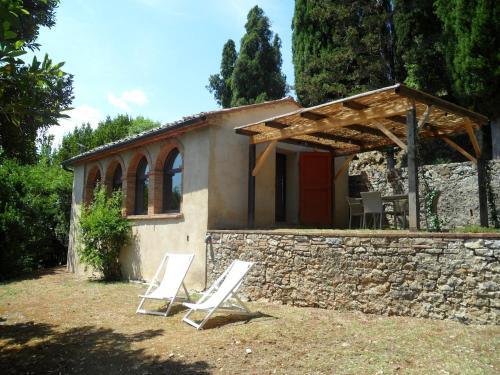 a couple of white chairs in front of a building at Residenza termale Monte Santo in San Casciano dei Bagni