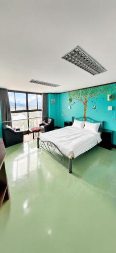 a bedroom with a bed and a blue wall at J Cafe & Hostel in Chiang Mai