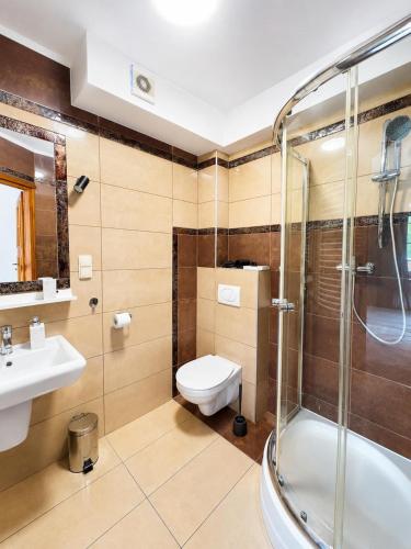 a bathroom with a shower and a toilet and a sink at Nota Bene Pokoje Gościnne Polanica Zdrój in Polanica-Zdrój
