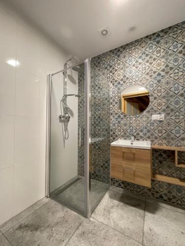 a bathroom with a shower and a sink at Domki hopSolina in Zawóz
