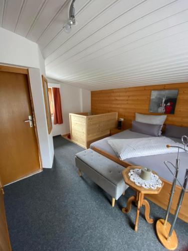 a bedroom with a large bed and a table at Ferienwohnung Bergheimat in Wenns