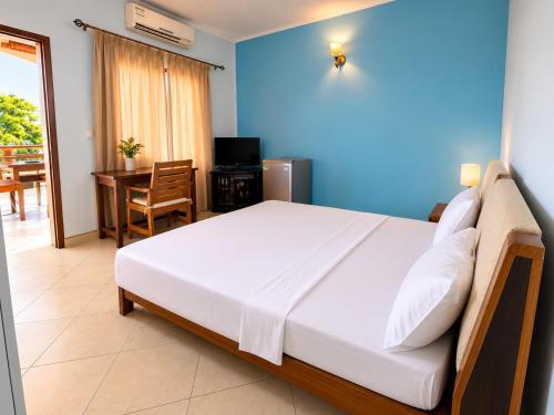 a bedroom with a large bed and a table and chairs at Chambre à louer in Moroni