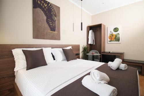 a bedroom with a large white bed with towels on it at Velorè Boutique Hotel in Tirana