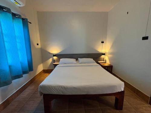 a bedroom with two beds and a blue window at Coconut Bungalow in Nai Yang Beach