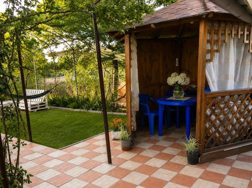 a gazebo with a blue table in a garden at Лана бугаз in Karolino-Buhaz
