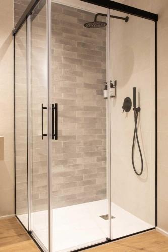 a shower with a glass enclosure in a bathroom at Alojamientos El Parque in Rute