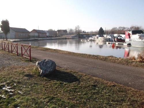a rock sitting on the side of a river with boats at Gite les Rosiers in Traubach-le-Bas
