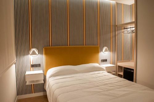 a bedroom with a large bed and two night stands at Alojamientos El Parque in Rute