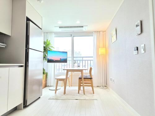 a kitchen with a table and a view of a balcony at Stayrium Sagajeong in Seoul