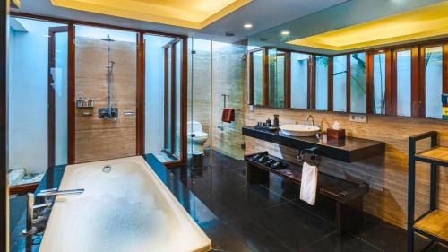 a large bathroom with a tub and a sink at The Kharma Villas Yogyakarta in Yogyakarta