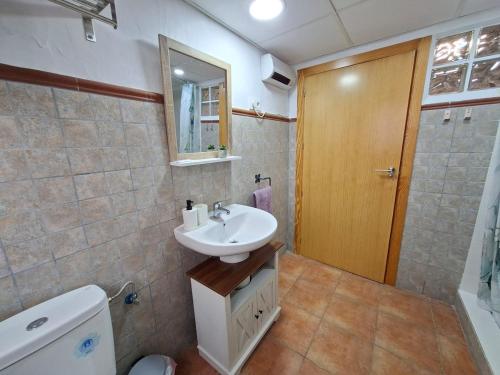 a bathroom with a sink and a toilet and a mirror at Villa Rueda in Moratalla