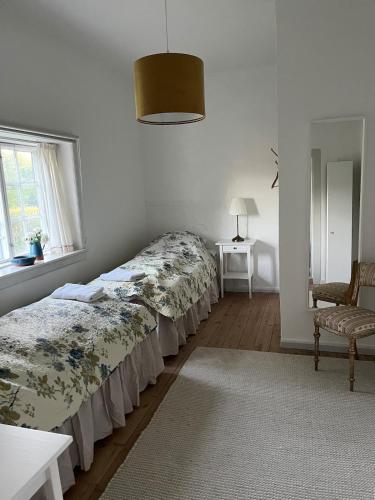 a bedroom with a bed and a chair and a window at The South Wing at Højbygård in Rødby