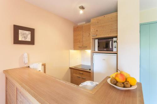 a kitchen with a bowl of fruit on a counter at Résidence Pierre & Vacances Le Clos d'Eguisheim in Eguisheim