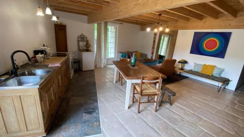 a kitchen and living room with a table and a couch at Moulin sous la Vergne in Nanteuil-en-Vallée