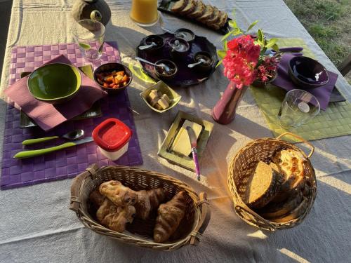 a picnic table with two baskets of food and flowers at La Parenthèse Béarnaise in Bonnut