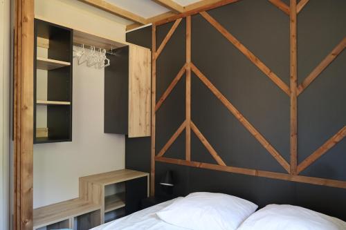 a bedroom with a wooden canopy bed and a black wall at Valterra Lodges à Châtillon-en-Diois in Châtillon-en-Diois