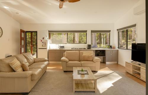 a living room with a couch and a table at Oakey Creek Retreat in Gheerulla