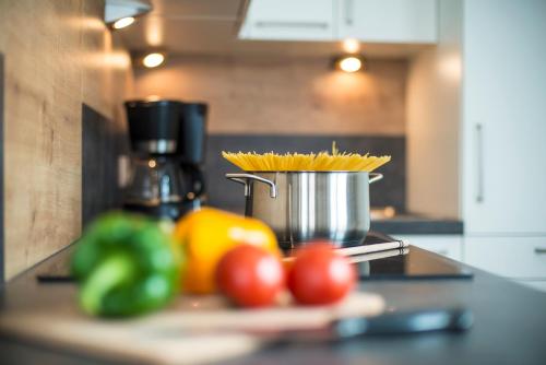a kitchen counter with tomatoes and a bucket of spaghetti at Tobhartbauer in Dorfgastein