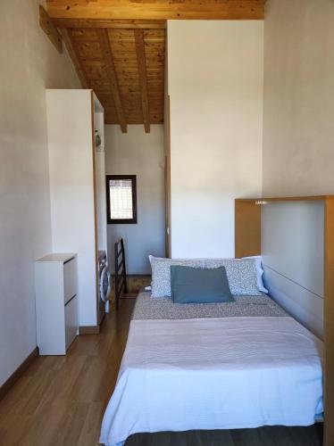 a bedroom with a large white bed with blue pillows at Casita in Castrojeriz