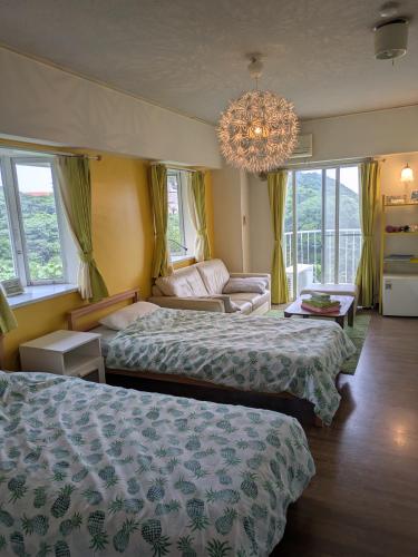 a hotel room with two beds and a chandelier at ビーチキャッスルマイウェイ in Shimoda