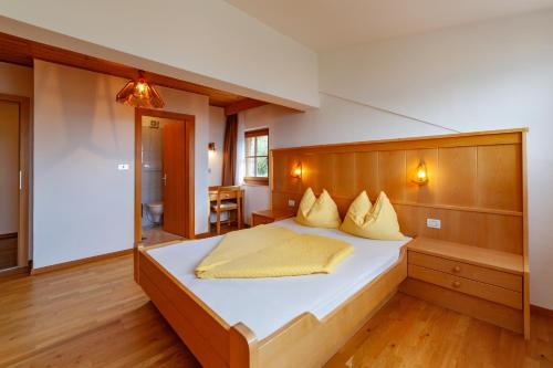 a bedroom with a large bed with a wooden headboard at Krebishof Agriturismo in Schenna