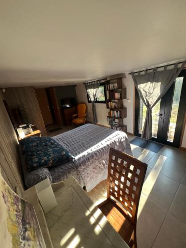 a bedroom with a bed and a table and a chair at Les Angères in Saint-Martin-d'Uriage