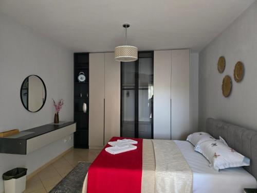 a bedroom with a bed with a red blanket on it at Puzzle Apart Rooms in Tirana