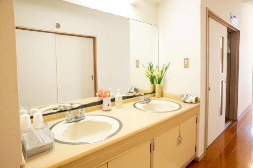 a bathroom with two sinks and a large mirror at Mansyuya in Isozaki