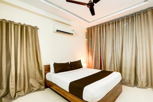 a bedroom with a bed and a ceiling fan at Hotel O Vyb Hotels in Hyderabad