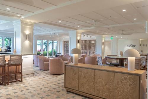 a lobby with a waiting area with chairs and tables at Exclusive Kauai Beachfront Resort with Dining, Bar, Spa, Pool & Waterslide in Lihue