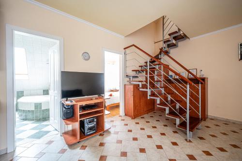 a living room with a staircase and a tv and a room at Gere Apartment de Luxe in Harkány