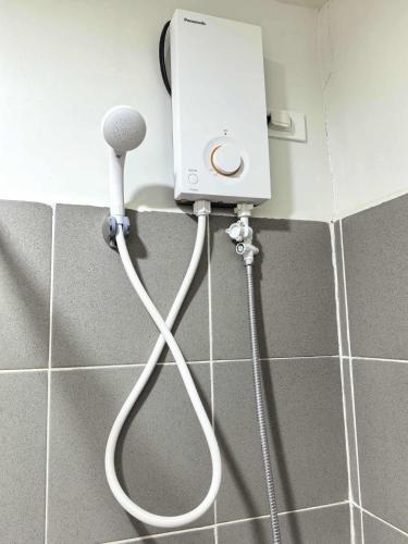 a blow dryer on a wall in a bathroom at Spacious Studio w Pool, Gym, Smart Lock, Netflix in Puerto Princesa City