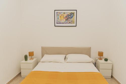 a white bedroom with a bed and two night stands at Villa Zoe in Specchiolla