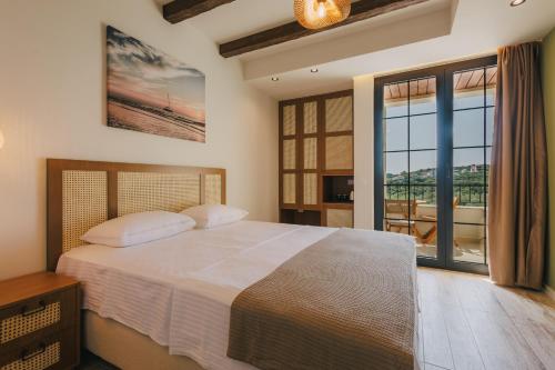 a bedroom with a large bed and a large window at Val D'or Olive Village in Ulcinj
