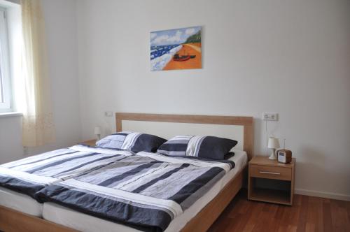 a bedroom with a large bed with blue and white sheets at Ferienhaus Lutowsee in Grammertin