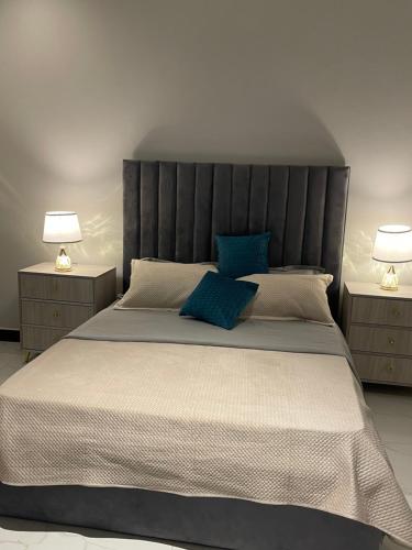 a bedroom with a large bed with two lamps at Bellwether Heights Kyanja in Kampala