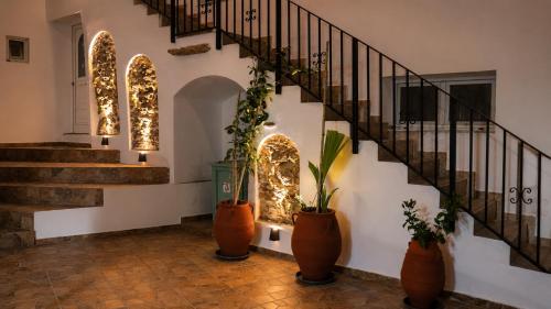 a hallway with a staircase and three potted plants at Aethra Seaview Suites in Kerames