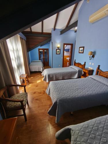 a hotel room with two beds and a chair at Hotel Balcon de Aguera in San Martín