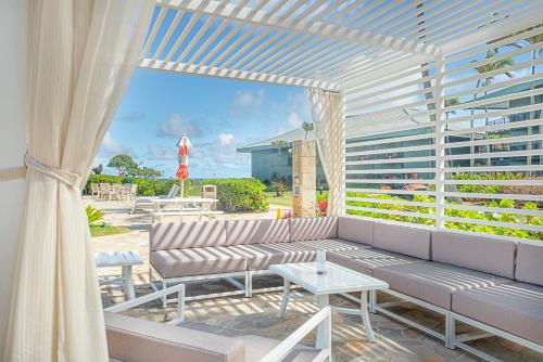 a patio with a couch and a table and a building at Exclusive Kauai Beachfront Resort with Dining, Bar, Spa, Pool & Waterslide in Lihue