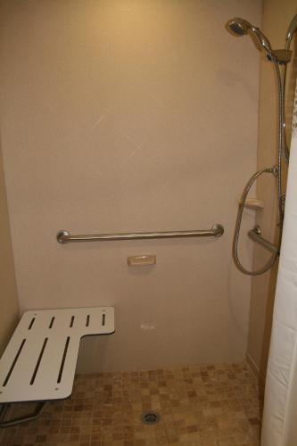 a bathroom with a white bench in a shower at McKnight Hotel in Pittsburgh