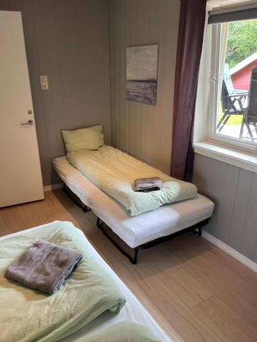 two beds in a small room with a window at Spacious apartment in Kristiansand with EV Station in Kristiansand