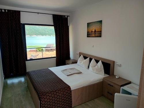 a bedroom with a bed and a large window at DiBosco House in Dubova