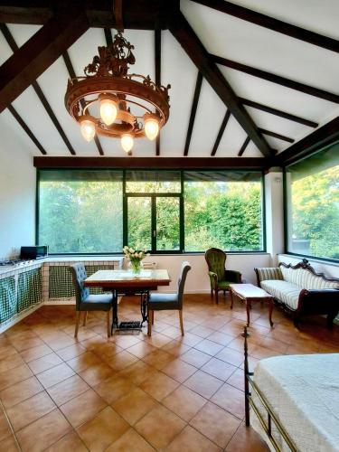 a living room with a chandelier and a table and chairs at Il giardino delle cince in Borgo Ticino