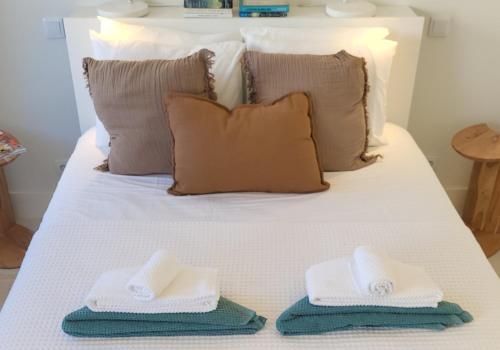a bed with two towels sitting on top of it at Villa Graça Olhão in Olhão